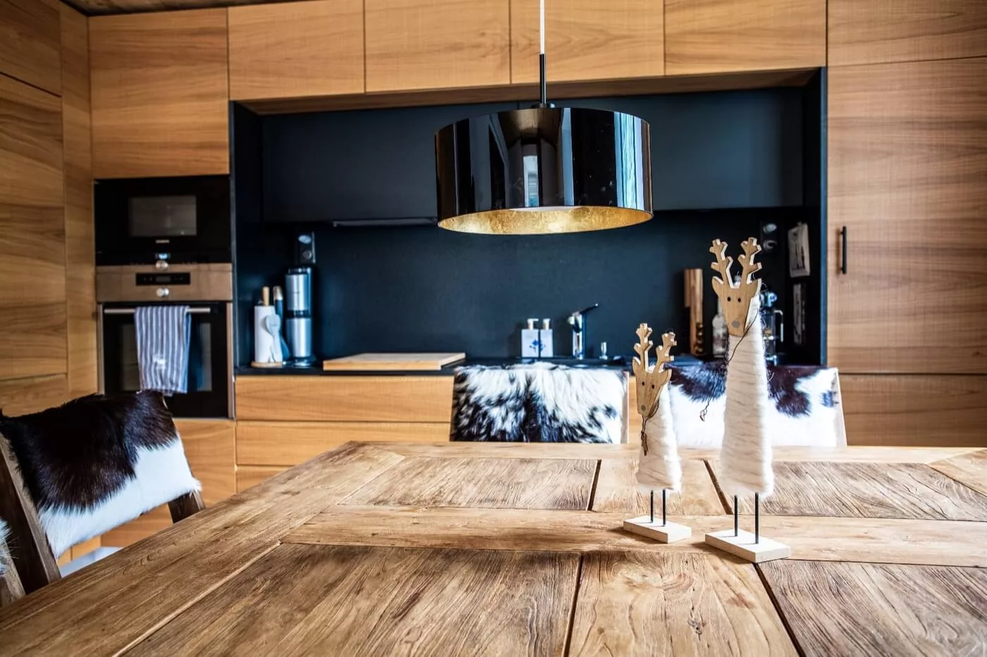Chalets: the redesigned attic of L'Eglise in Crans-Montana and the wood and black kitchen of Les Praz in Chamonix.